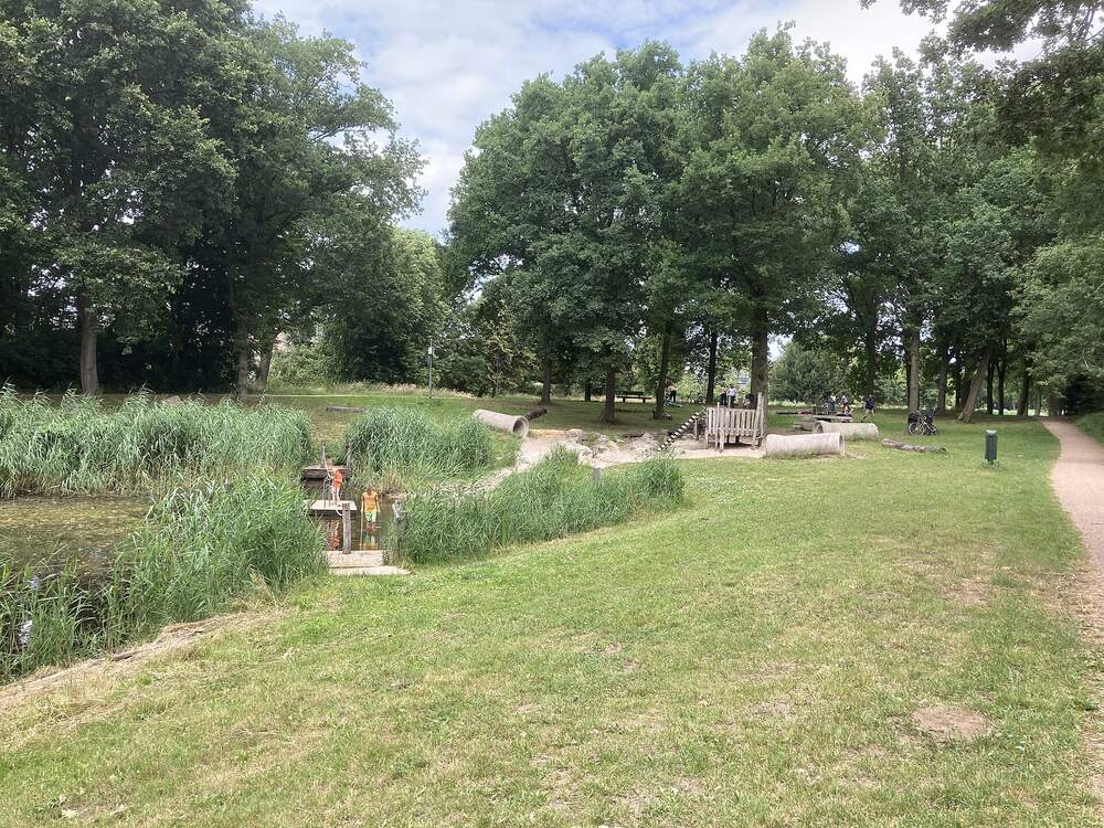 Waterspeelplek met ondiepe waterloop en wandelpad in het Warandepark in Huizen